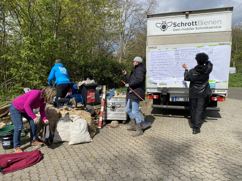 Das Bild zeigt die Säcke voller Müll sowie die Bestenliste, in welcher die gesammelten Mengen pro Teilnehmer festgehalten wurden.